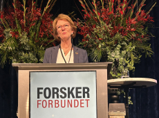 Kvinne på Forskerforbundets talestol. Foto: Marina Tofting / DNVA