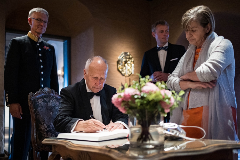 Prisvinner Luis Caffarelli signerer gjesteboken på Akershus slott. Rundt ham står hans kone Irene Gamba, statsråd Ola Borten Moe og kommandant Arne Opperud