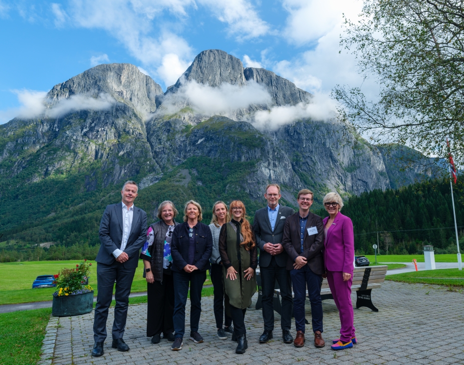 Gruppebilde fra tunet på Kavli Moen Gård med et fjell i bakgrunnen