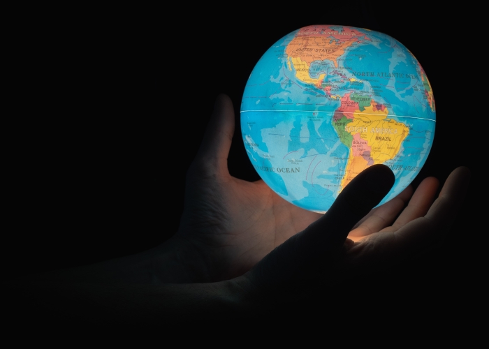 Hender som holder en lysende globus. (Foto: Greg Rosenke / Unsplash)