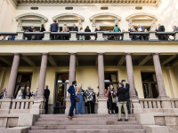 Feststemte folk som står utenfor ærverdighus.